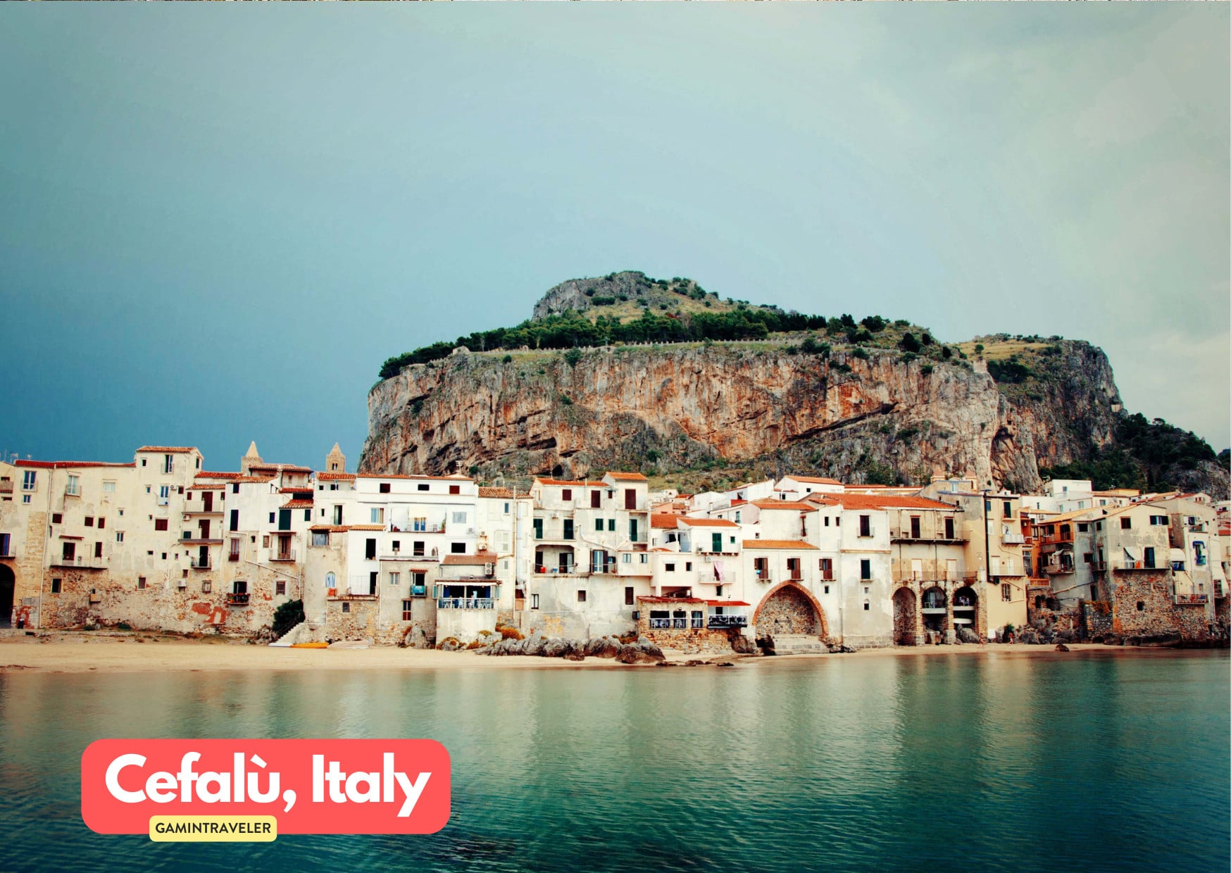 a group of buildings on a beach in Cefalu Italy